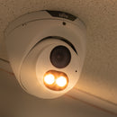 Security camera with warm light illumination on a ceiling